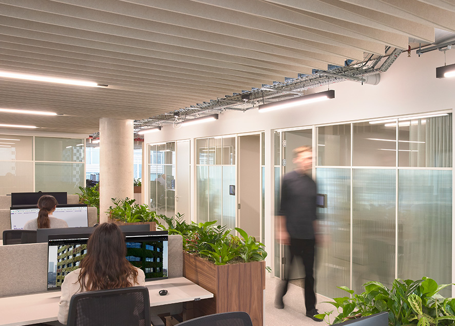 Staff working in an open-plan workstation at Gleeds London HQ featuring Acoufelt Acoustic Ceiling Baffles